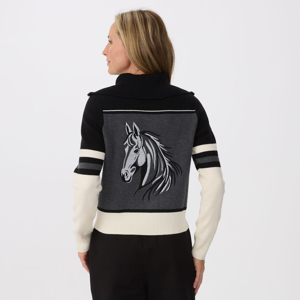 A woman shown from the back wearing a black and dark gray knit sweater with cream-colored sleeves and a large embroidered horse head on the back panel.